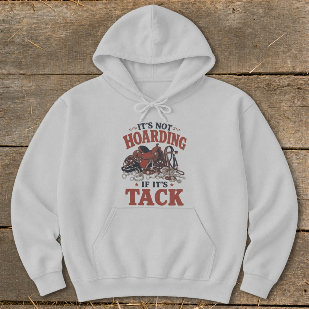 White hoodie with "It's Not Hoarding If It's Tack" text and horse tack graphic.