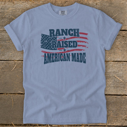 Light blue t-shirt with distressed American flag graphic and "Ranch Raised American Made" text.