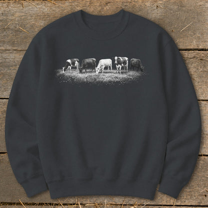 Sweatshirt with a graphic of five cows grazing in a field of wildflowers.