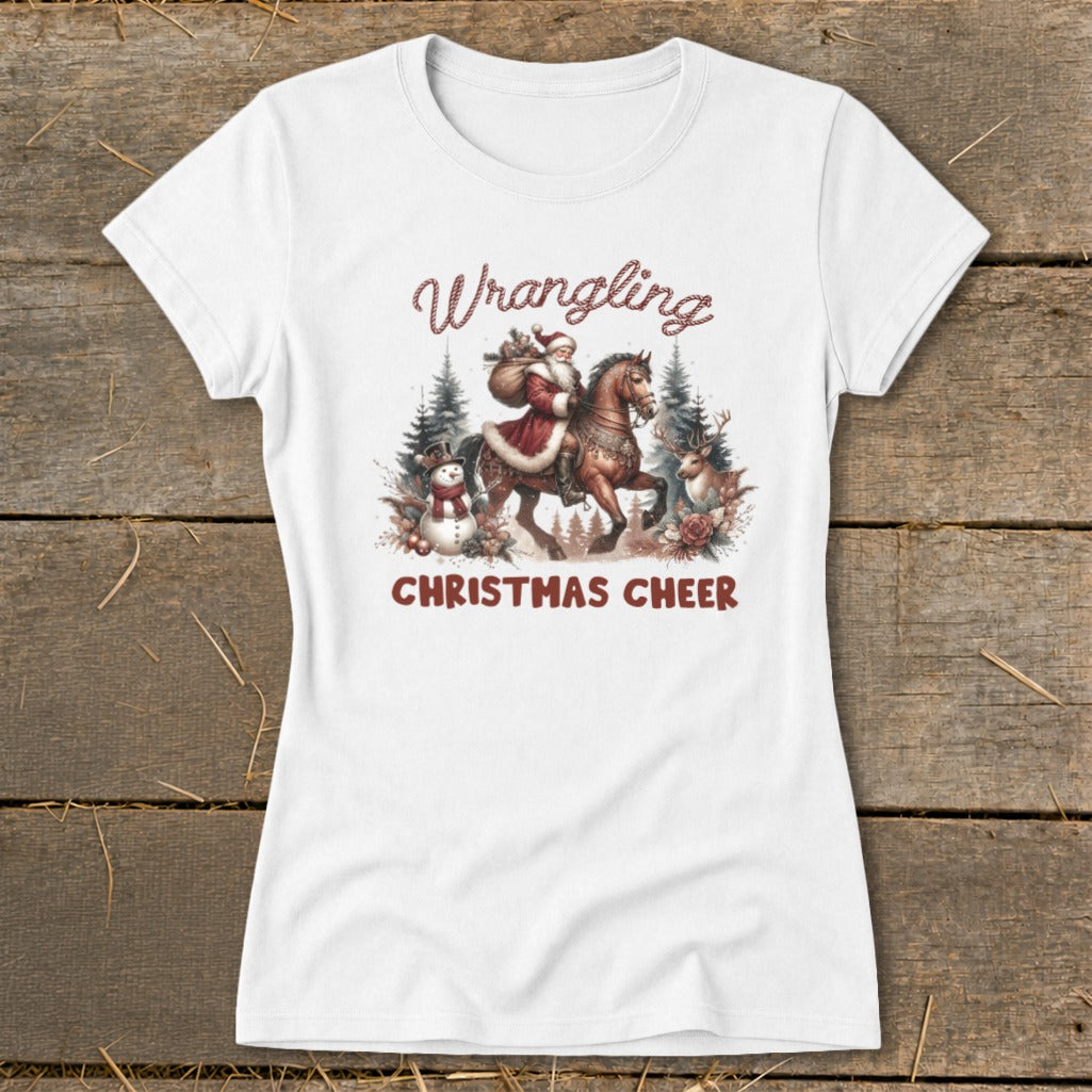 White t-shirt with "Wrangling Christmas Cheer" text and a watercolor illustration of Santa on horseback.