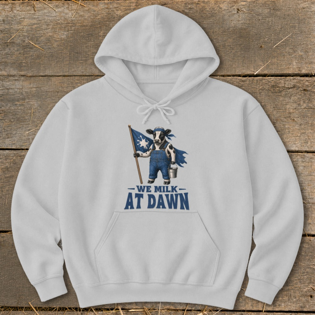 White hoodie with a graphic of a cow holding a flag and wearing overalls with text "We Milk At Dawn".