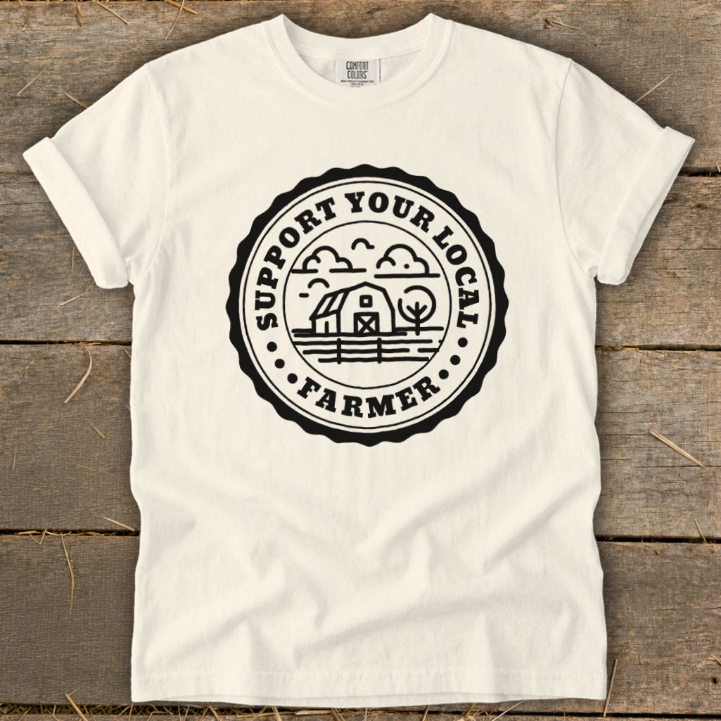 Cream t-shirt with black circular logo featuring barn, tree, and "Support Your Local Farmer" text.