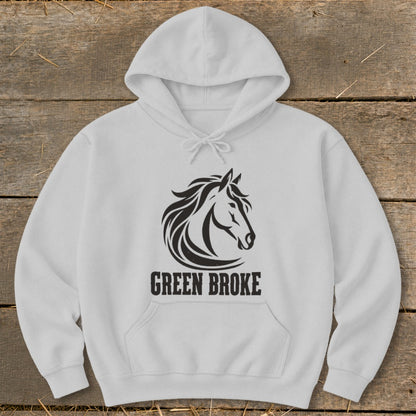 A light gray hooded sweatshirt with a black horse graphic and the text "GREEN BROKE" on a wooden background.