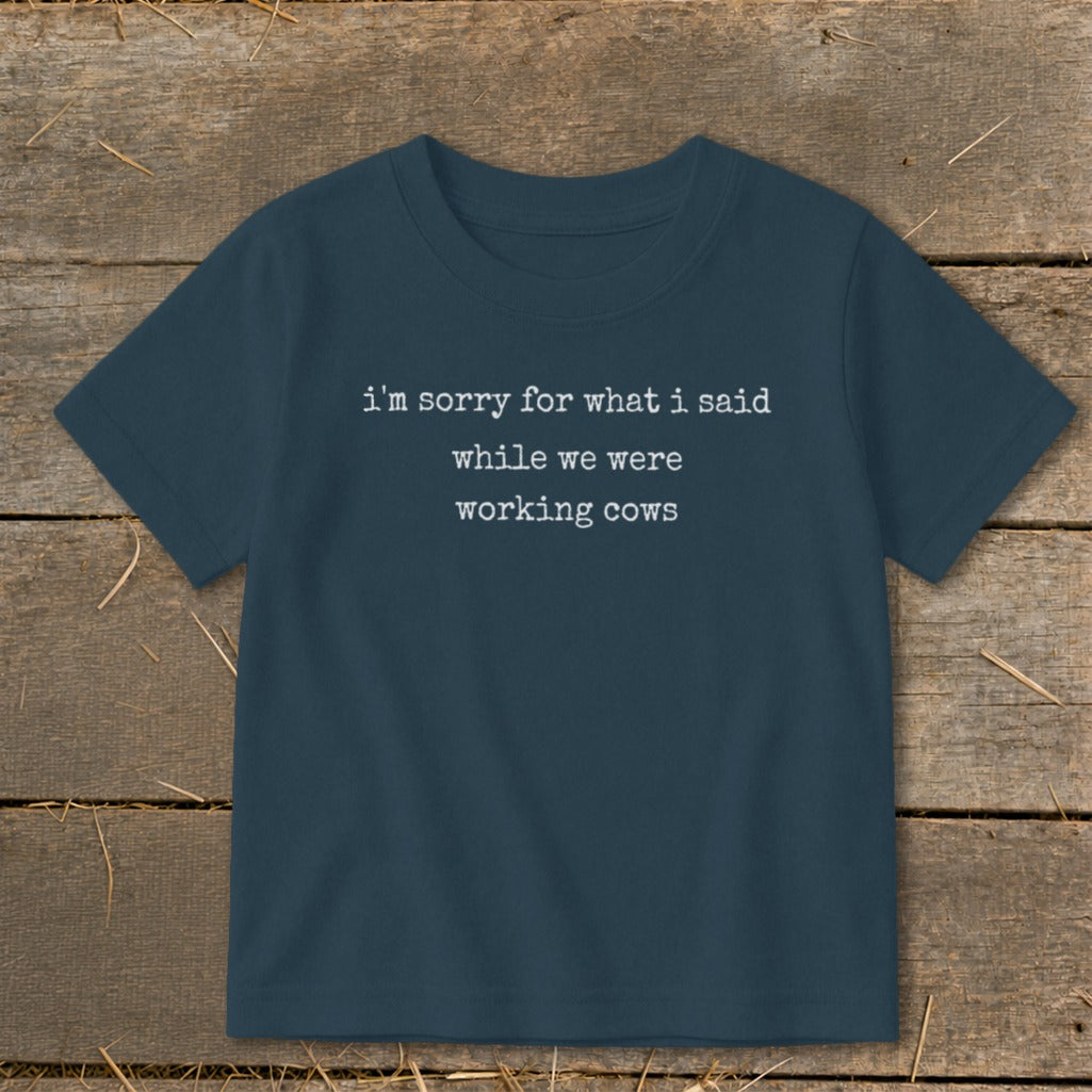 Navy t-shirt with white text: "i'm sorry for what i said while we were working cows"