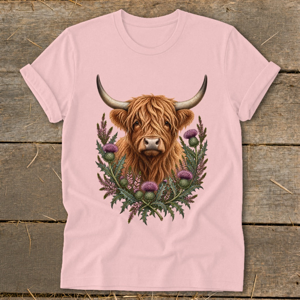 Highland cow portrait surrounded by thistles on a pink t-shirt.