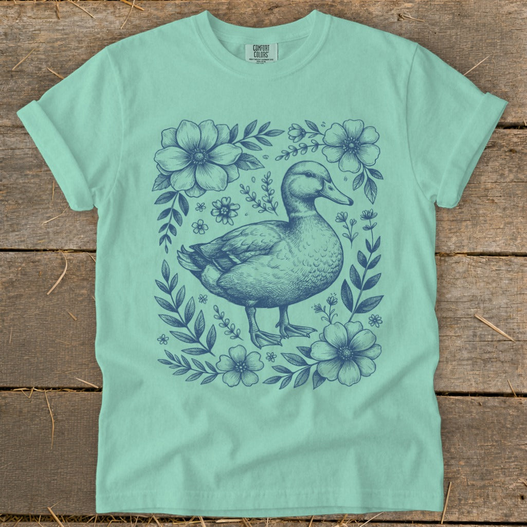 Mint t-shirt with a blue floral border and a sketched duck design.
