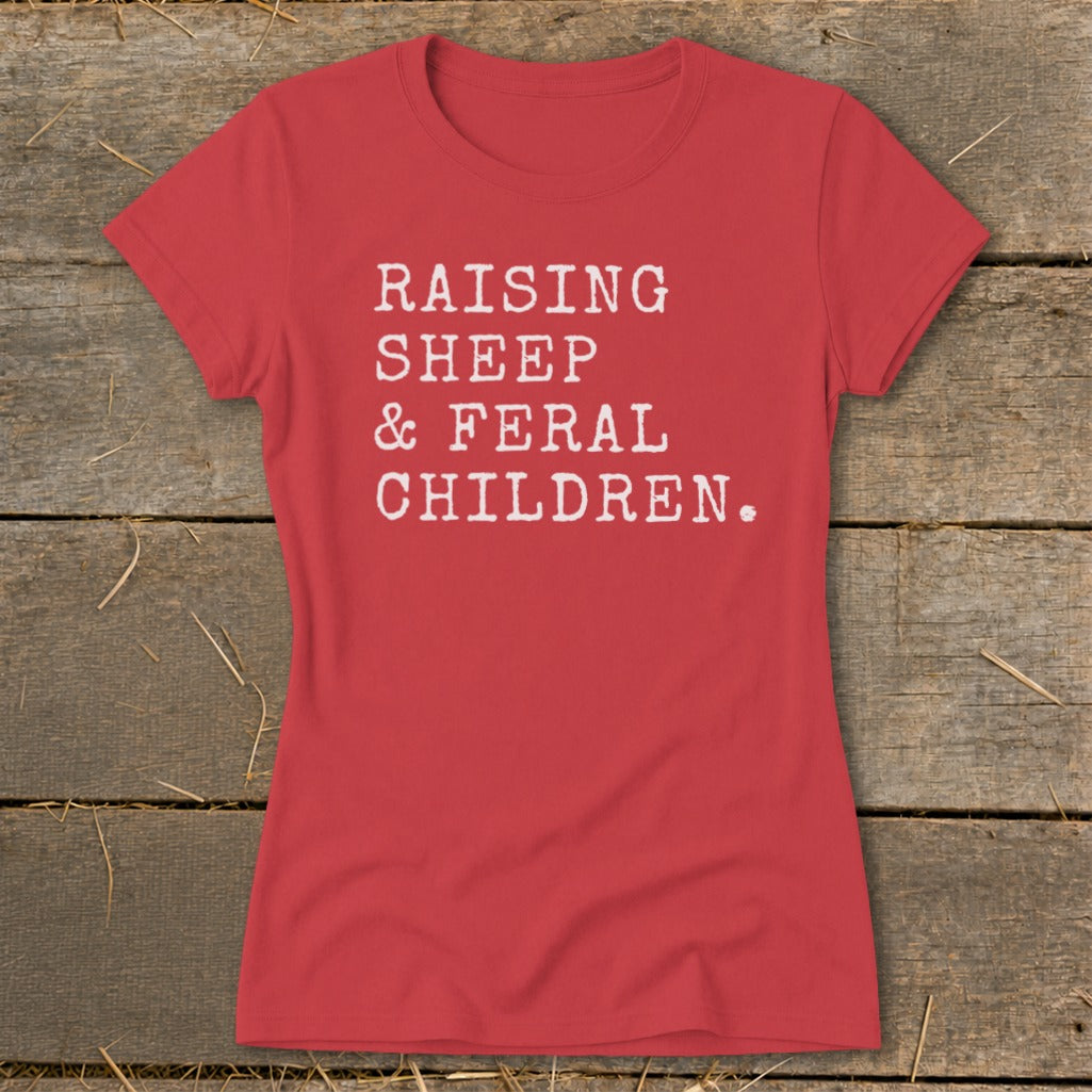 Red t-shirt with white text reading "RAISING SHEEP & FERAL CHILDREN."