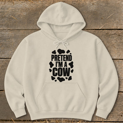 Cream hoodie with "PRETEND I'M A COW" text and cow print spots.