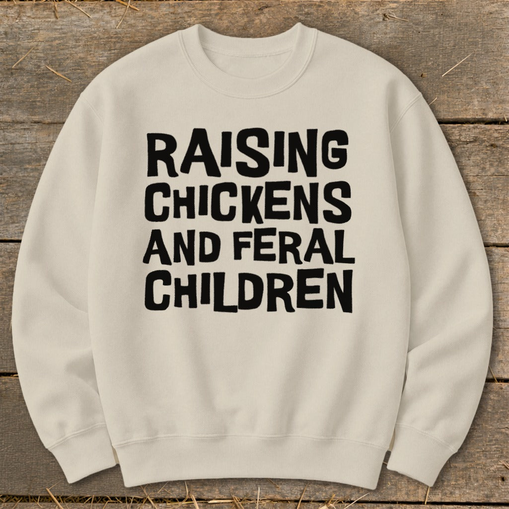 Cream sweatshirt with black text "RAISING CHICKENS AND FERAL CHILDREN".