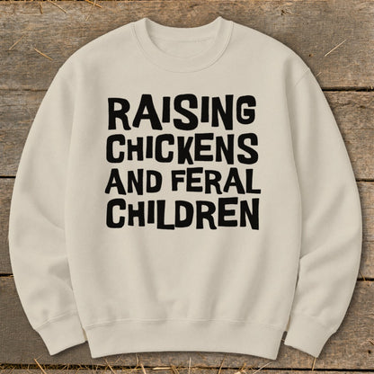 Cream sweatshirt with black text "RAISING CHICKENS AND FERAL CHILDREN".