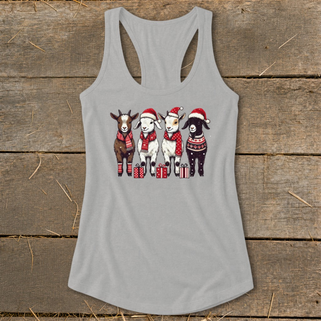 Four goats in Santa hats and scarves stand with Christmas gifts.