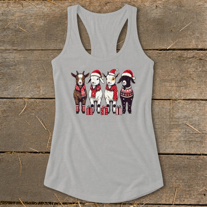 Four goats in Santa hats and scarves stand with Christmas gifts.