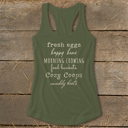 Green tank top with white text: fresh eggs happy hens, morning crowing, feed buckets, cozy coops, muddy boots.