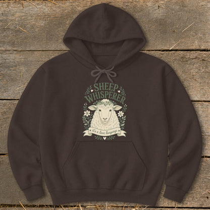 Dark brown hoodie with a sheep illustration and "Sheep Whisperer" text.