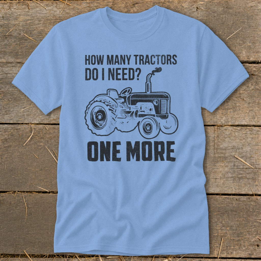 Light blue t-shirt with a black tractor graphic and text "HOW MANY TRACTORS DO I NEED? ONE MORE".