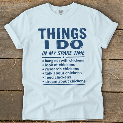 White t-shirt with blue text listing chicken-related activities.