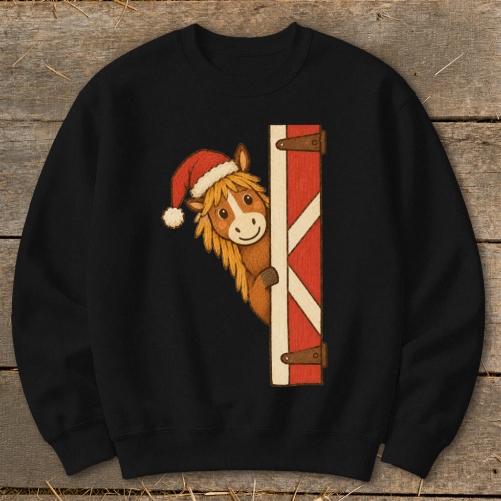 Black sweatshirt with cartoon horse wearing Santa hat peeking from barn door.