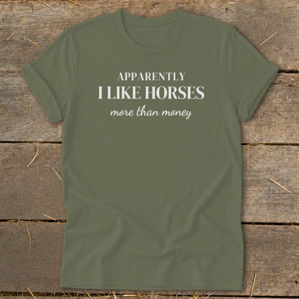 Olive green t-shirt with white text "APPARENTLY I LIKE HORSES more than money".