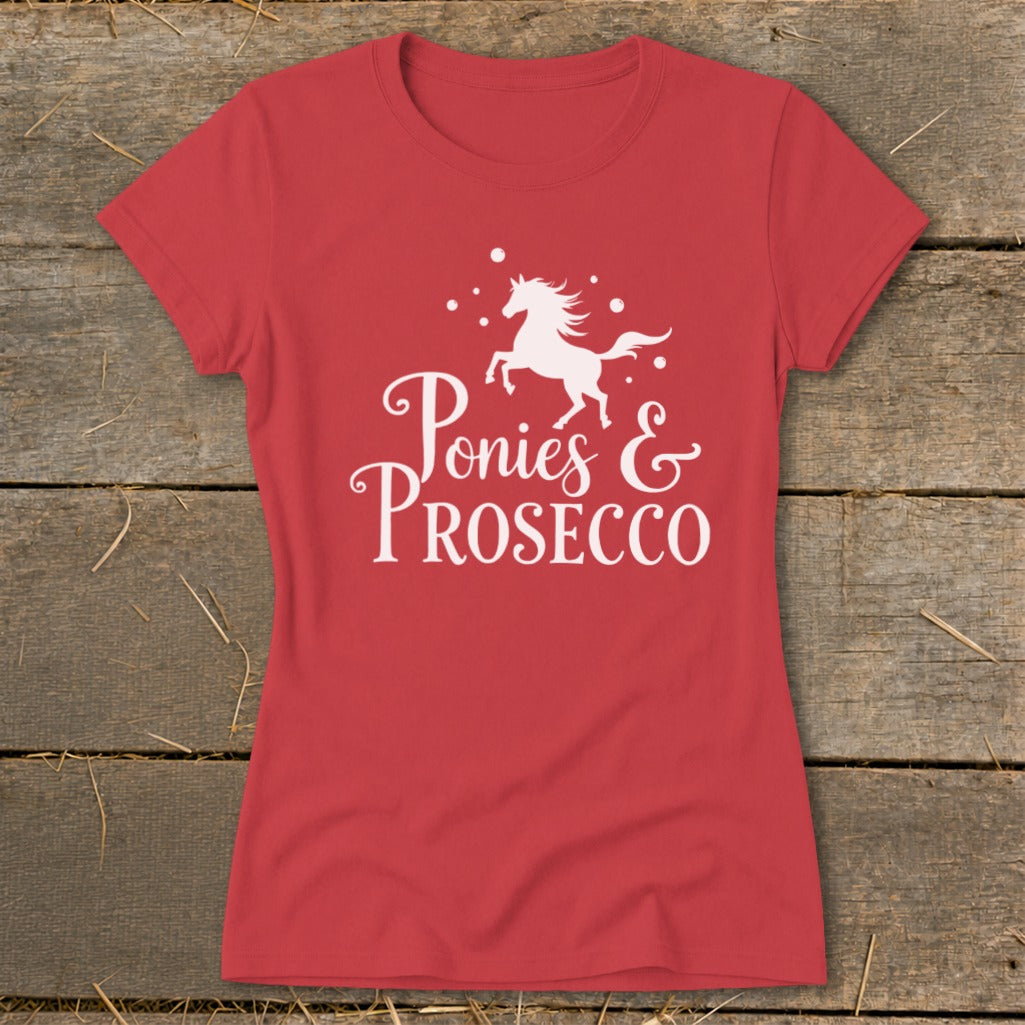 Red t-shirt with white text and a unicorn silhouette reading "Ponies & Prosecco".