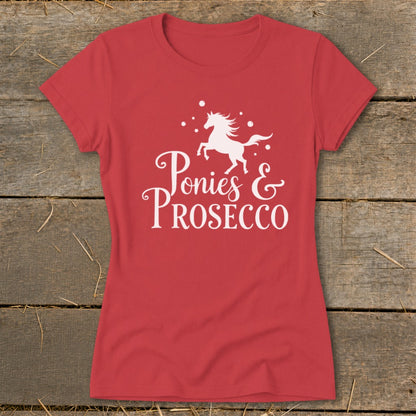 Red t-shirt with white text and a unicorn silhouette reading "Ponies & Prosecco".