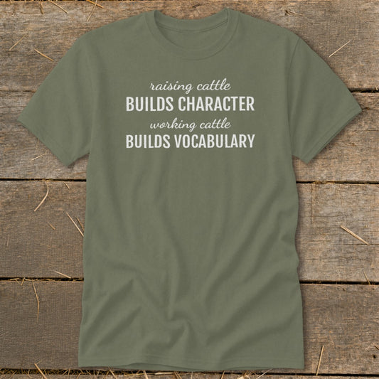Olive green t-shirt with white text "Raising cattle builds character, working cattle builds vocabulary."