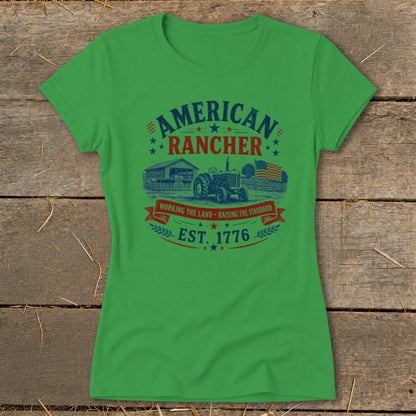 Green t-shirt with "American Rancher" text, tractor, barn, and American flag graphic.