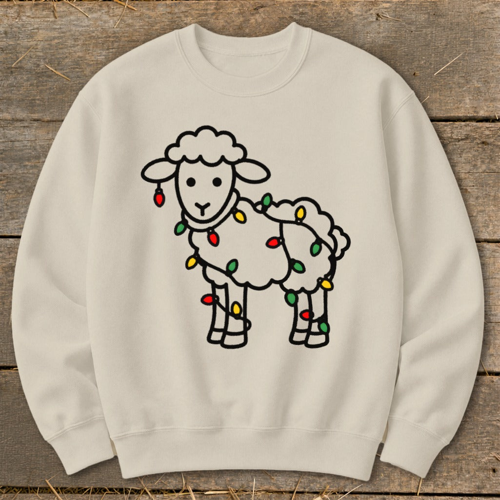 A cream-colored crewneck sweatshirt featuring a black-outlined cartoon sheep wrapped in colorful holiday lights.