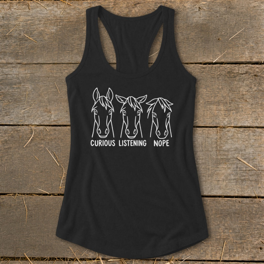 A black women's racerback tank top featuring a white graphic of three horse heads with the captions "Curious," "Listening," and "Nope."