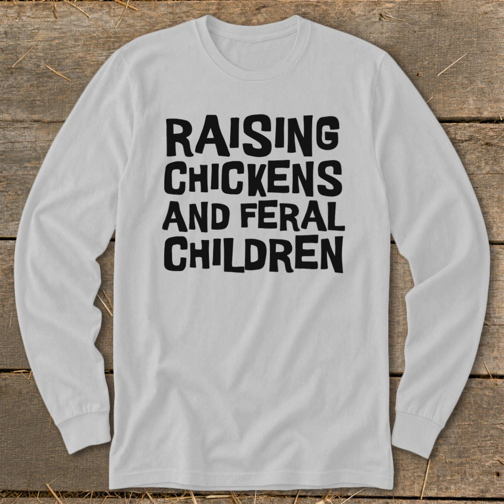 White long-sleeve shirt with black text: Raising Chickens And Feral Children.