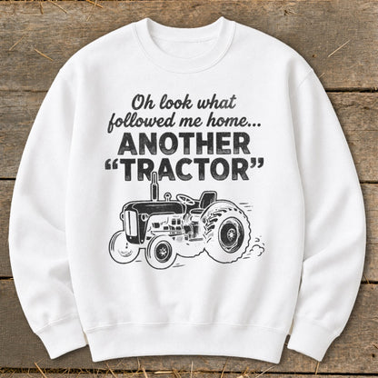 White sweatshirt with text "Oh look what followed me home... ANOTHER TRACTOR" and a tractor graphic.