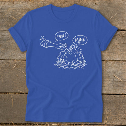 Blue t-shirt with white line drawing of a chicken guarding eggs, text "eggs?" and "MINE".