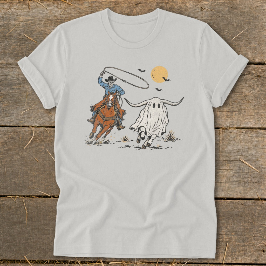 Cowboy skeleton on horse lassos a running ghost with horns under a harvest moon.