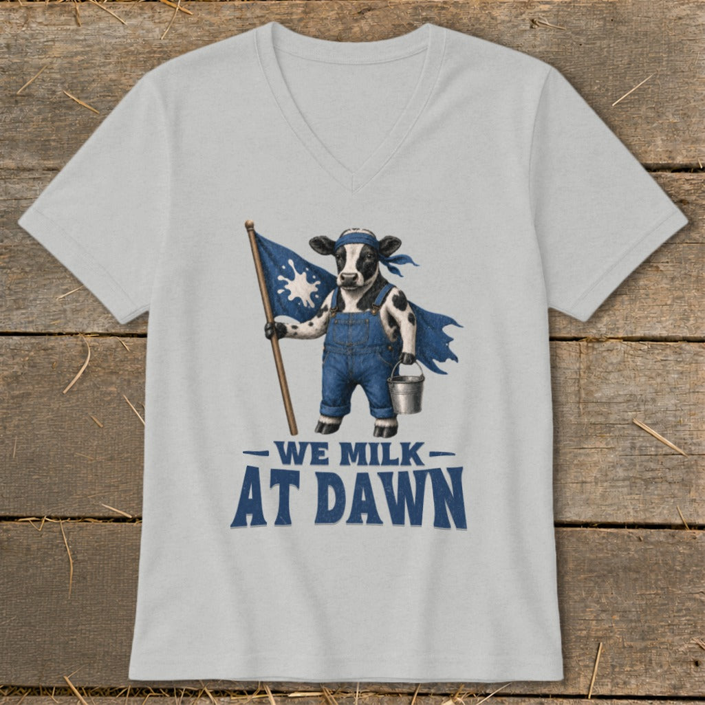 Cow wearing overalls, holding a flag and bucket, with text "WE MILK AT DAWN".
