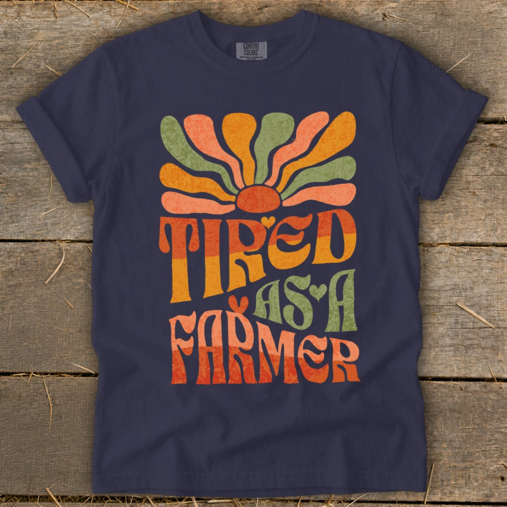 Navy t-shirt with retro sun graphic and text "Tired as a Farmer".