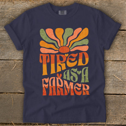 Navy t-shirt with retro sun graphic and text "Tired as a Farmer".