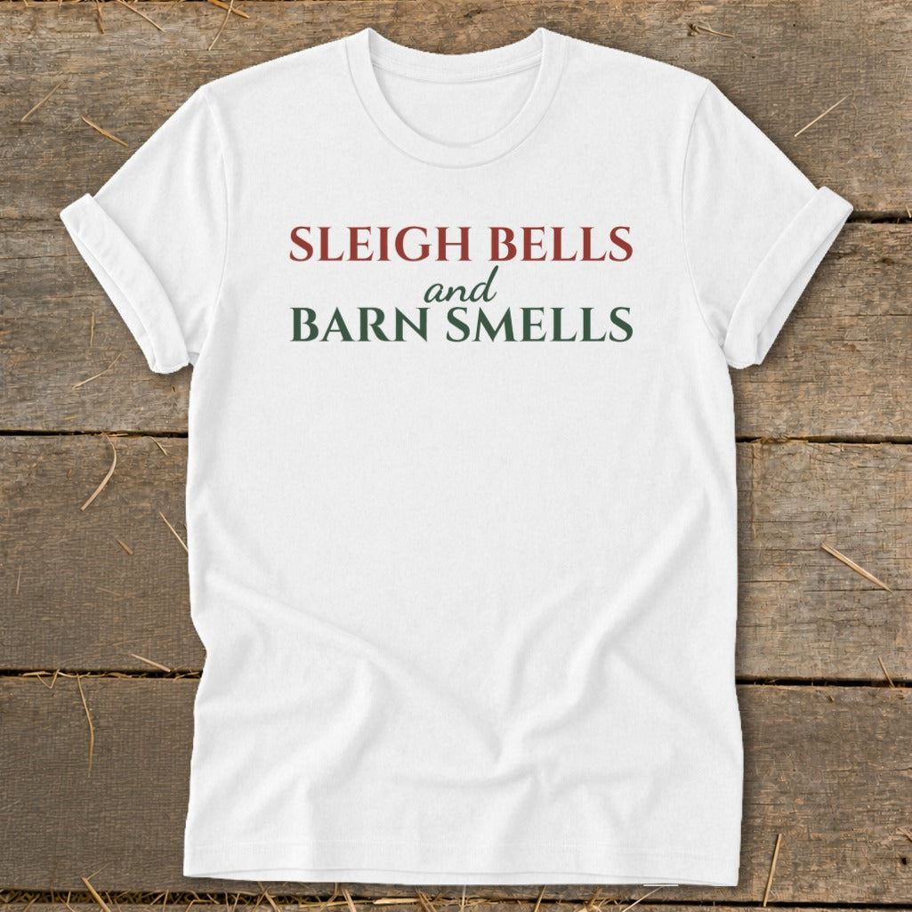 White t-shirt with "Sleigh Bells and Barn Smells" text in red and green.