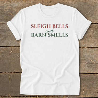 White t-shirt with "Sleigh Bells and Barn Smells" text in red and green.