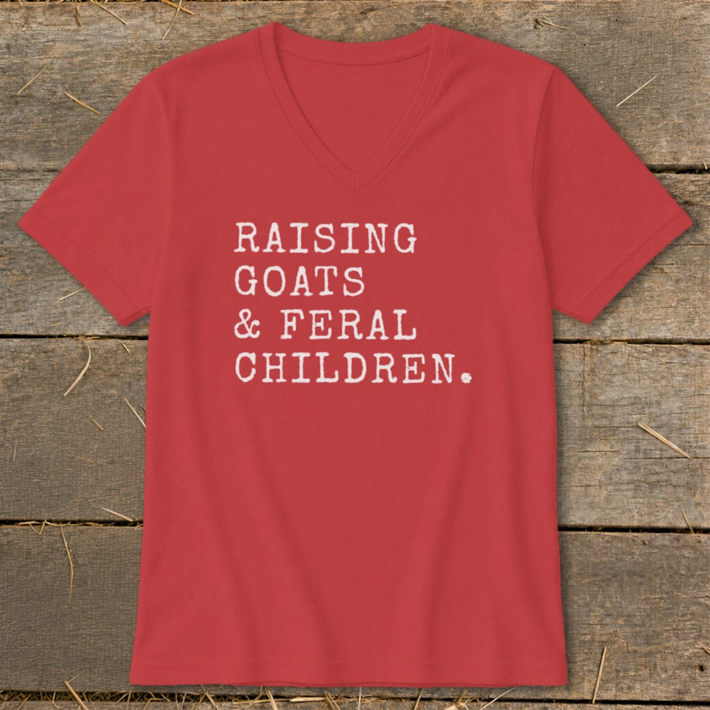 Red V-neck t-shirt with white text: "Raising Goats & Feral Children."