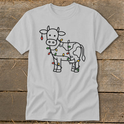 Light grey t-shirt with a black outline drawing of a cow decorated with colorful Christmas lights.