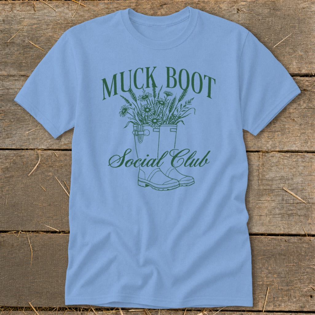 Light blue t-shirt with green "Muck Boot Social Club" text and floral design.