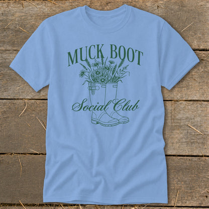 Light blue t-shirt with green "Muck Boot Social Club" text and floral design.