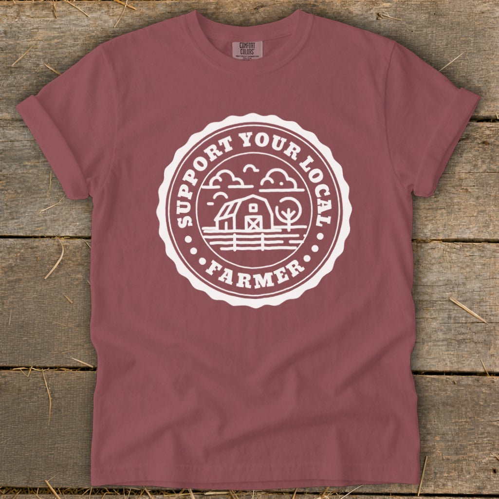 Maroon t-shirt with white "Support Your Local Farmer" circular graphic featuring a barn and trees.
