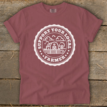 Maroon t-shirt with white "Support Your Local Farmer" circular graphic featuring a barn and trees.