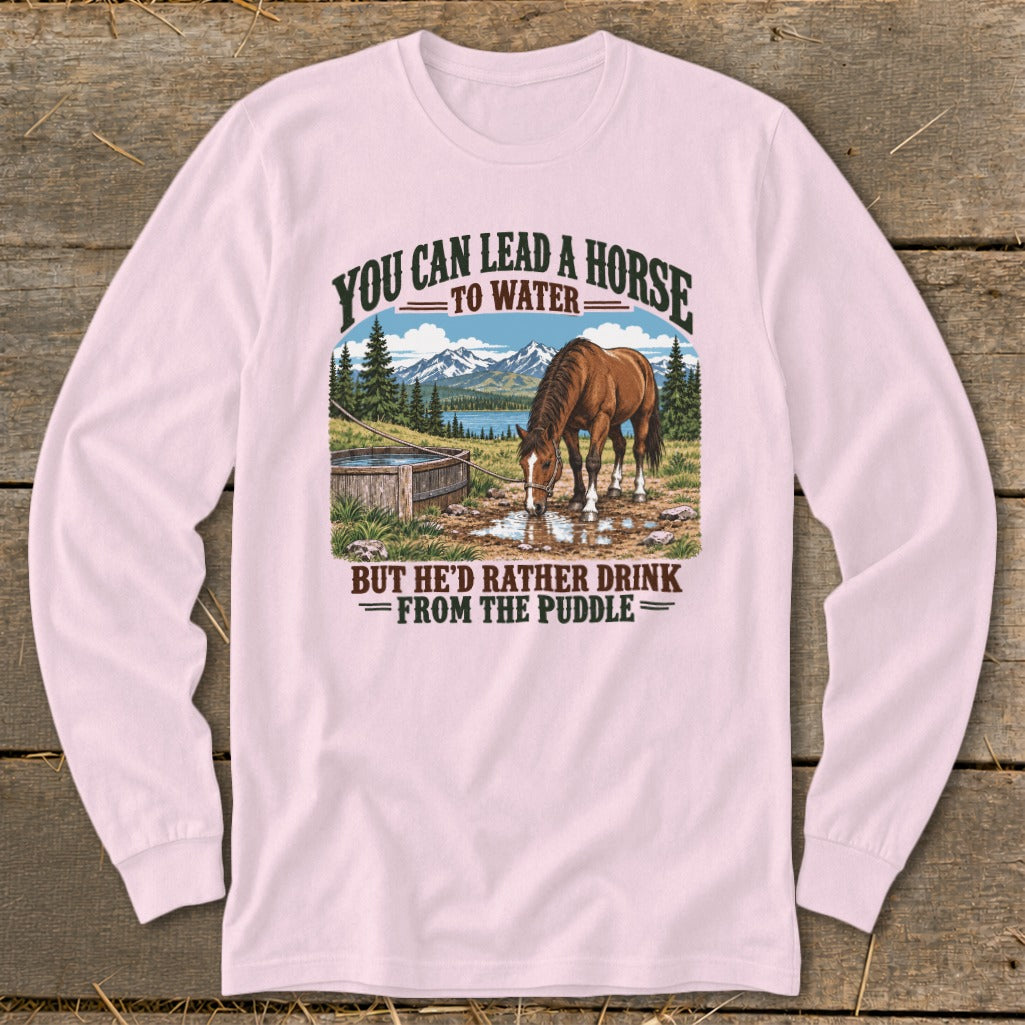 Light pink long-sleeve t-shirt featuring a graphic of a horse drinking from a puddle with text.