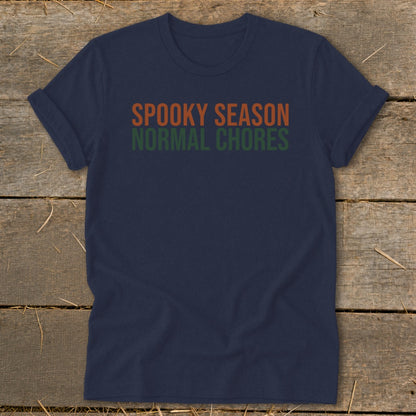Navy t-shirt with orange text "SPOOKY SEASON" and green text "NORMAL CHORES".