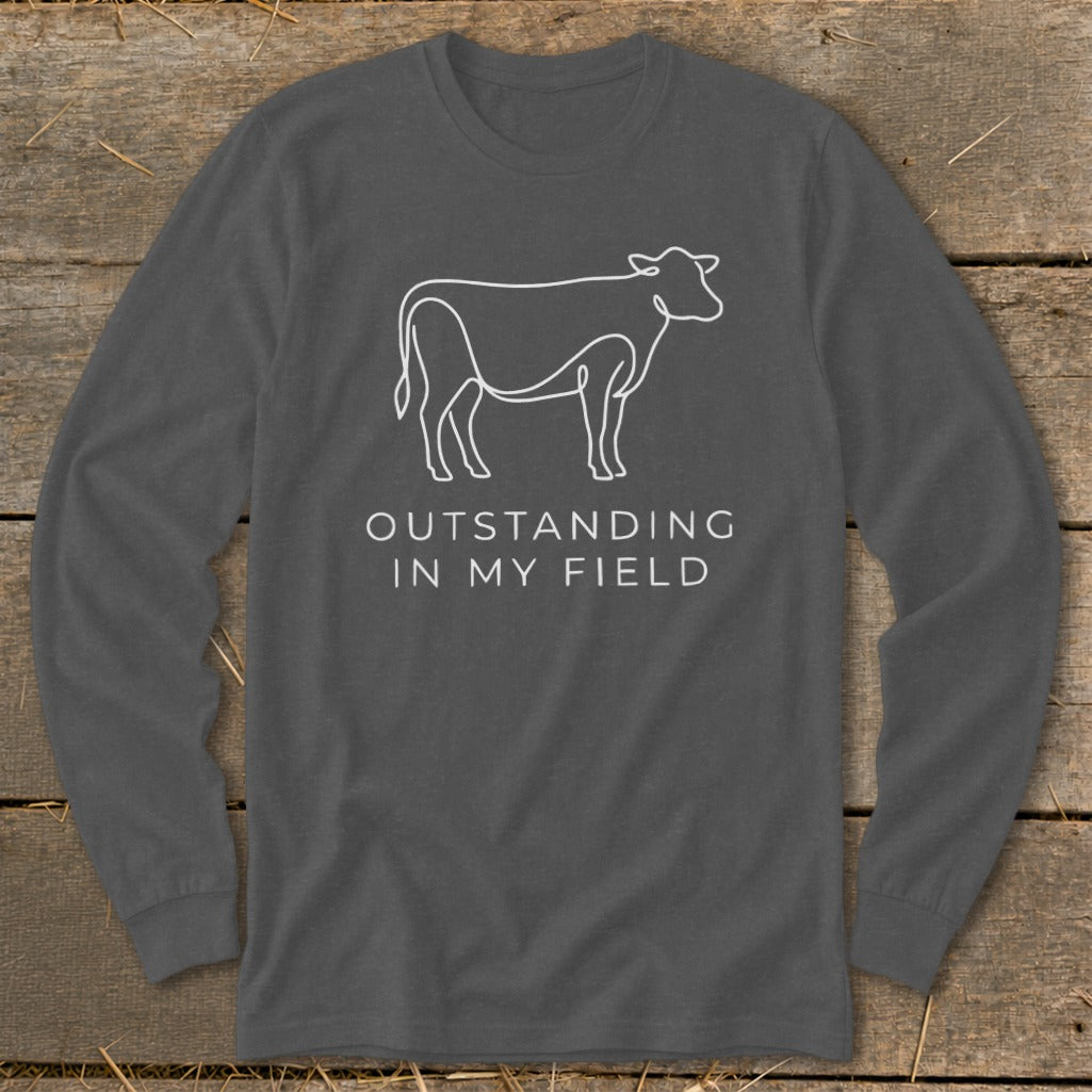Long sleeve shirt with a white line drawing of a cow and text "OUTSTANDING IN MY FIELD".