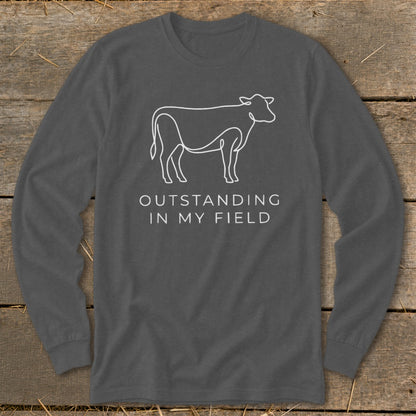 Long sleeve shirt with a white line drawing of a cow and text "OUTSTANDING IN MY FIELD".