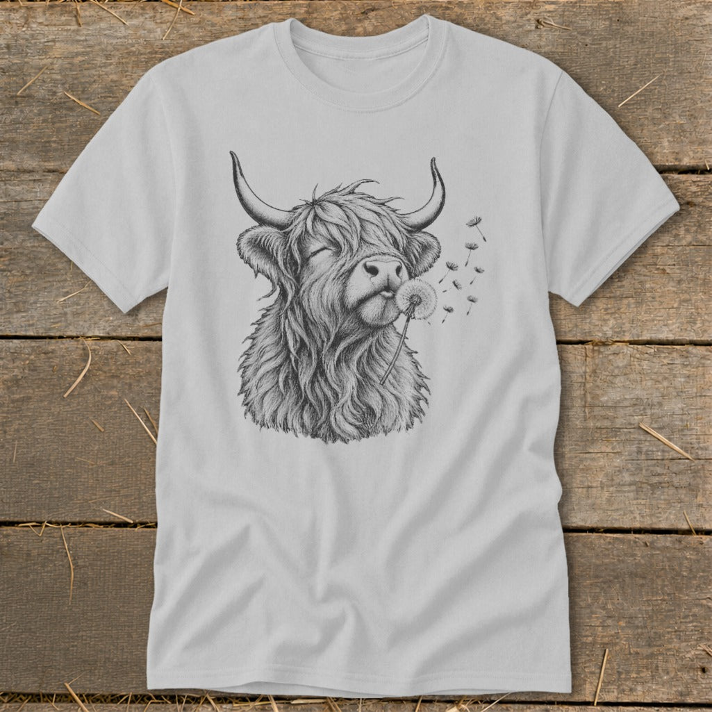Light gray t-shirt with sketch of Highland cow blowing dandelion seeds.