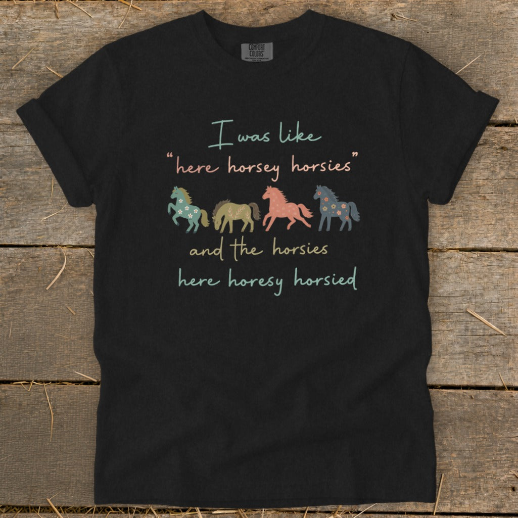 Black t-shirt with text "I was like 'here horsey horsies' and the horsies here horesy horsied" and four horses.