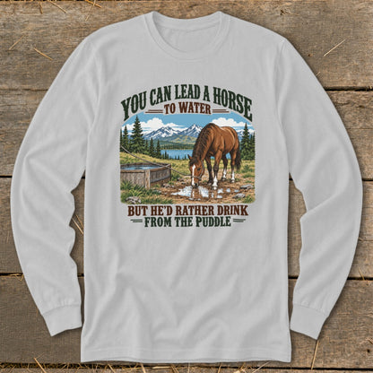 Light gray long-sleeve t-shirt with graphic of a horse drinking from a puddle and text reading YOU CAN LEAD A HORSE TO WATER BUT HE'D RATHER DRINK FROM THE PUDDLE.